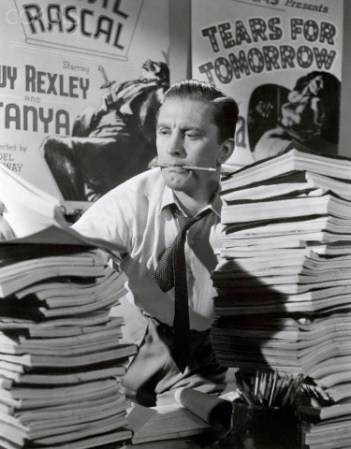 1952 --- Original caption: 1952-Movie still of Kirk Douglas struggling behind a desk full of scripts in "The Bad and the Beautiful," directed by Vincente Minelli. --- Image by © Corbis